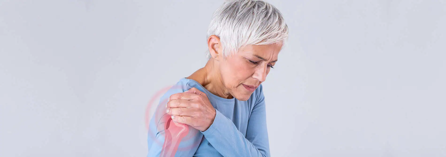 woman in pain holding her shoulder